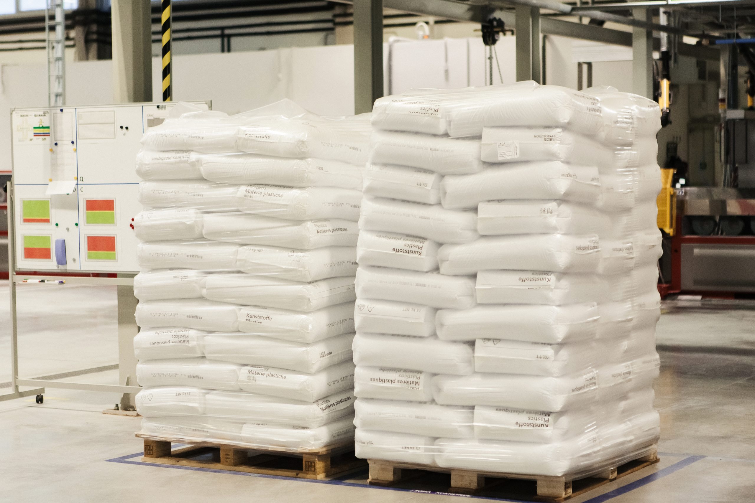 white bags evenly and neatly folded onto a pallet stand in a warehouse for storing consumable plastic materials